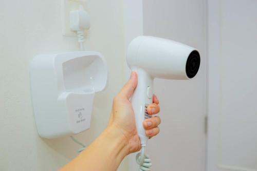 a person holding a blow dryer in a bathroom at -Garden View- Mount Austin Aeon IKEA 10 mins - A13A in Johor Bahru