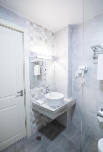 a white bathroom with a sink and a shower at Astana Palace in Gori