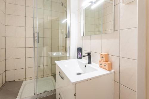 une salle de bain blanche avec un lavabo et une douche dans l'établissement Magnifique appartement 6Pers Stationnement Gratuit Centre 1, à Mulhouse