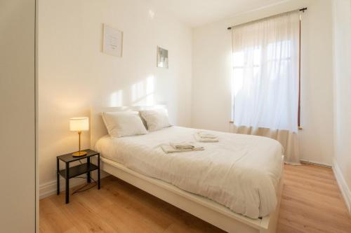 une chambre blanche avec un lit et une fenêtre dans l'établissement Magnifique appartement 6Pers Stationnement Gratuit Centre 1, à Mulhouse