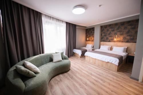 a hotel room with two beds and a couch at Astana Palace in Gori
