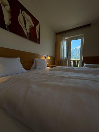 a hotel room with two beds and a window at Pension Plattenhof in Telfs