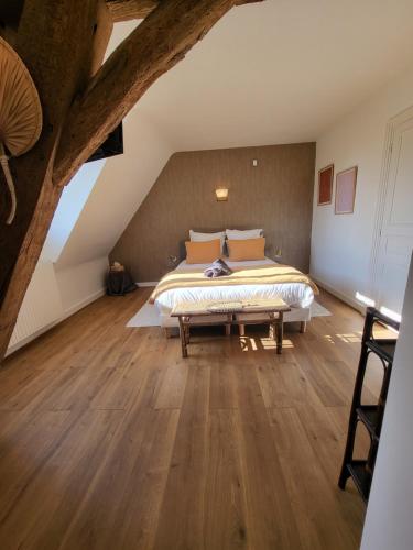 a bedroom with a bed and a wooden floor at Domaine de charme - Les Places in Lassay-sur-Croisne