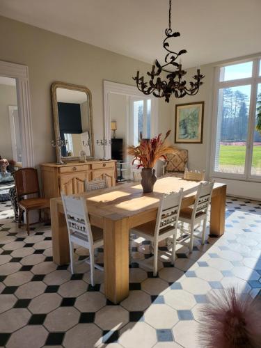 a dining room with a table and chairs and a mirror at Domaine de charme - Les Places in Lassay-sur-Croisne