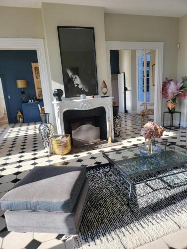 a living room with a fireplace and a couch at Domaine de charme - Les Places in Lassay-sur-Croisne