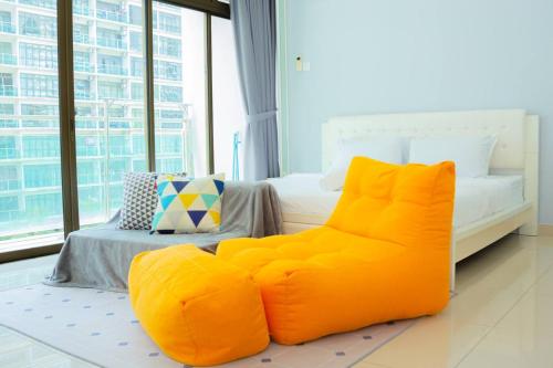 an orange chair in a bedroom with a bed at -Garden View- Mount Austin Aeon IKEA 10 mins - A13A in Johor Bahru