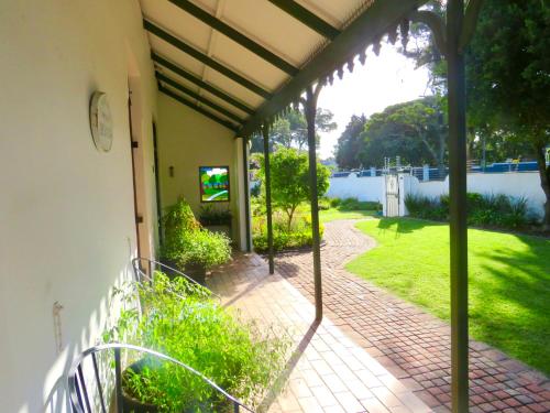 a porch with a view of a yard at Whistlewood Guesthouse Walmer, Port Eizabeth in Port Elizabeth
