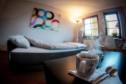 a room with a bed and a cup of coffee on a table at Apartament Karlikowska in Sopot