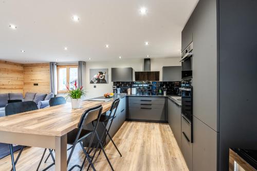 une cuisine et une salle à manger avec une table et des chaises en bois dans l'établissement Valgardena, à Morzine