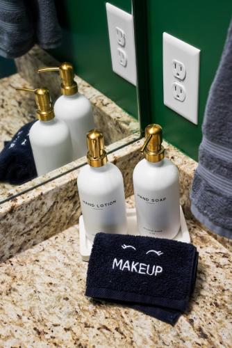 a bathroom counter with a mirror and two bottles of soap at Cozy & Spacious 2 King Beds Near UGA & Downtown in Athens