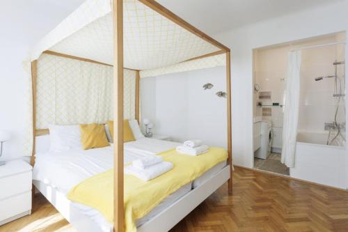 a bedroom with a canopy bed and a tub at Papageno Apartments in Vienna