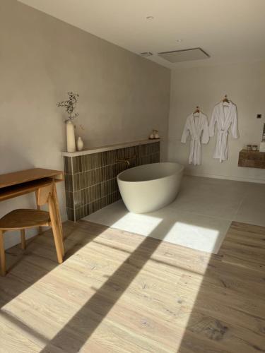 a bathroom with a large tub and two white shirts on the wall at Ferme La Clavière, Suite de Luxe Lou Estello in Mane
