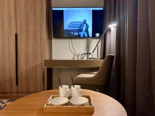 a room with a table with a tv on the wall at Luxury California King Suite with Pool and City View in Manila