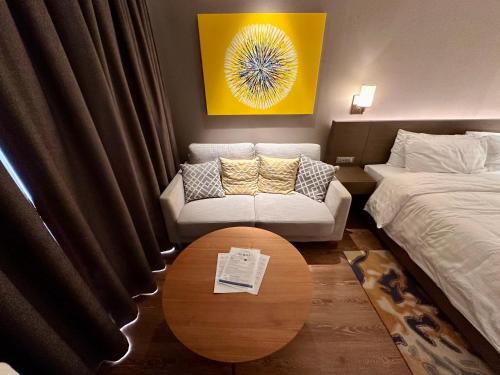 a room with a bed and a couch and a table at Luxury California King Suite with Pool and City View in Manila