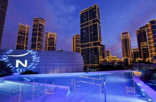 a swimming pool with a city skyline in the background at Luxury California King Suite with Pool and City View in Manila