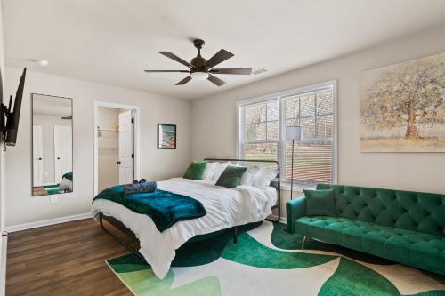 a bedroom with a bed and a green couch at Cozy & Spacious 2 King Beds Near UGA & Downtown in Athens