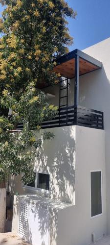 a balcony on the side of a building with a tree at شاليه ميلان Milan Chalet in Al Ḩamrāʼ
