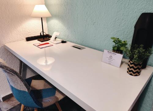 a white desk with a lamp and a chair at Boho Sea View Apartment in Elounda