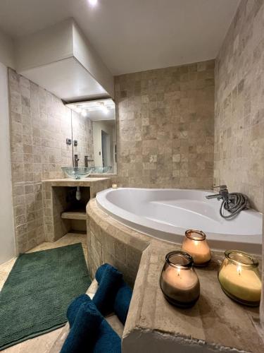 une grande salle de bains avec baignoire et tapis vert dans l'établissement Grand F1 Centre Historique Ecusson 10Min Comédie, à Montpellier
