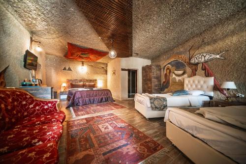 ギョレメにあるAdelya Cave Hotelのベッド2台とソファのある広い部屋