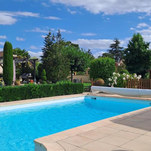 - une piscine dans une cour avec des buissons et des arbres dans l'établissement Le Clos Gwladys, à Chevigny-en-Valière
