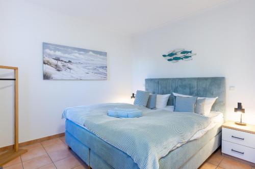 a bedroom with a large bed with a blue headboard at Friederike in Ahrenshoop