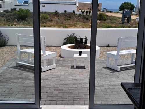 two white benches sitting next to a fire pit at Jacobsdaller #2 in Jacobs Bay