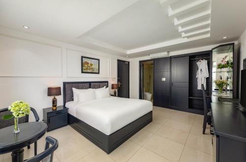 a bedroom with a bed and a table at Kay Han Riverfront Hotel Da Nang in Danang