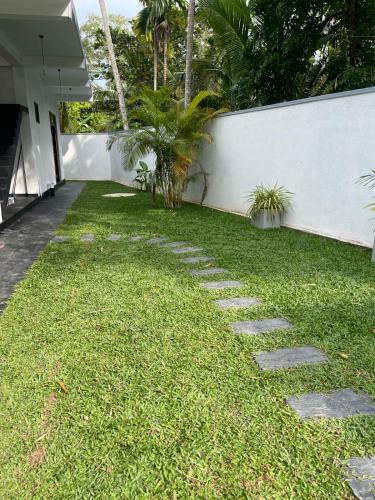 a garden with stepping stones in the grass at Garden Villa in Midigama