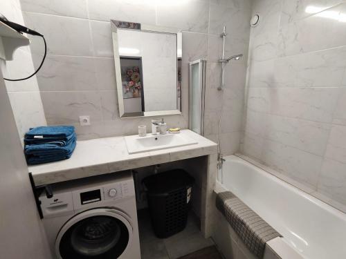 une salle de bain avec un lavabo et une machine à laver dans l'établissement Apt 9 personnes garage, Wi-Fi, tram, parking, climatisation, jeux, à Avignon