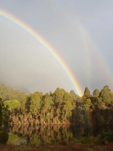 a rainbow in the sky over a forest at Tullah HideAway in Tullah