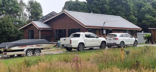 two trucks and a boat in front of a house at Tullah HideAway in Tullah