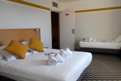 a hotel room with a bed with towels on it at La Maison des Ocres - Provence in Roussillon