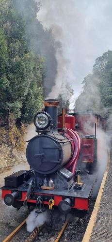 a steam engine train traveling down the tracks at Tullah HideAway in Tullah