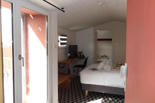 a bedroom with a bed and a desk in a room at La Maison des Ocres - Provence in Roussillon