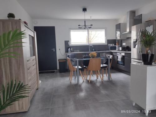 une cuisine et une salle à manger avec une table et des chaises dans l'établissement Maison de famille, à Saint-Julien-des-Landes