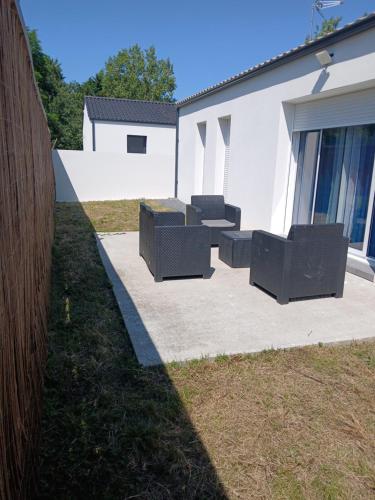- un ensemble de chaises assises sur une terrasse en béton dans l'établissement Maison de famille, à Saint-Julien-des-Landes