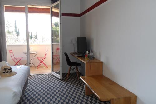a room with a bed and a desk with a computer at La Maison des Ocres - Provence in Roussillon