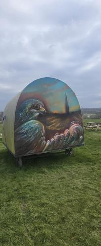 a largeruck with a painting on it in a field at Stonehenge Shepherds Huts in Durrington