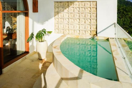a swimming pool in a house with a potted plant at The Kayuan in Kintamani