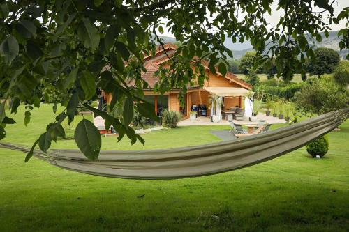 - un hamac dans une cour en face d'une maison dans l'établissement Magnifique Chalet avec piscine et salle de sport, à Peyrieu
