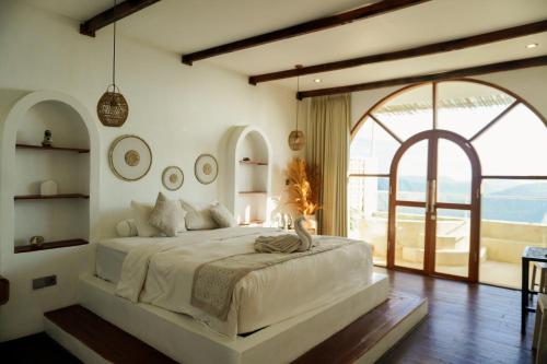 a bedroom with a large bed and a large window at The Kayuan in Kintamani