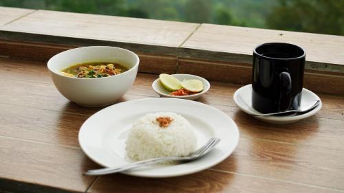 a table with a plate of rice and a bowl of soup at The Kayuan in Kintamani