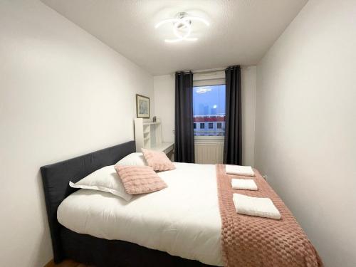 - une chambre avec un lit doté d'oreillers roses et d'une fenêtre dans l'établissement Magnifique appartement Fleur, à Saint-Louis