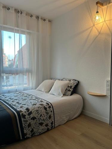 un lit dans une chambre avec une grande fenêtre dans l'établissement Séjour haut de gamme climatisé, spacieux, grand confort et terrasse, en famille ou entre amis, au Cap d'Agde