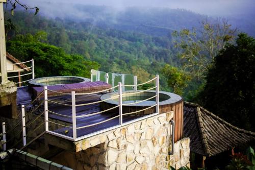 a building with a deck with a view of the mountains at The Kayuan in Kintamani