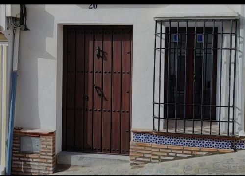 two doors on the side of a building at La Medina Baja in Setenil