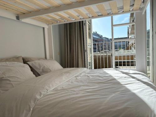 een slaapkamer met een bed en een groot raam bij Bayaux centrum Knokke in Knokke-Heist