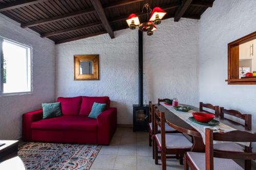 a living room with a red couch and a table at Heaven in Fenais da Luz