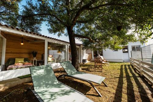 a patio with two chairs and a tree at Heaven in Fenais da Luz